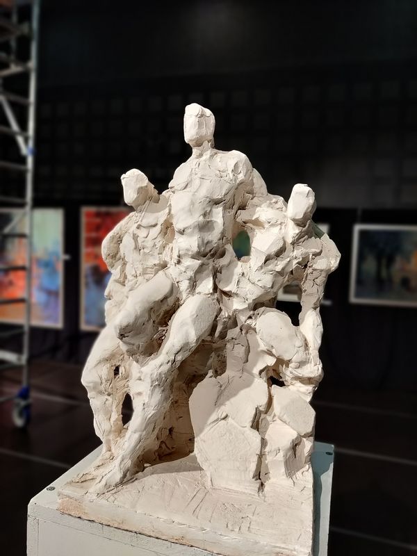 Une sculpture blanche représentant trois personnages
