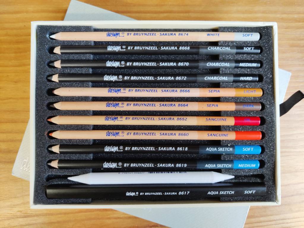 Boîte de dix crayons, une estompe et un crayon large dans de la mousse