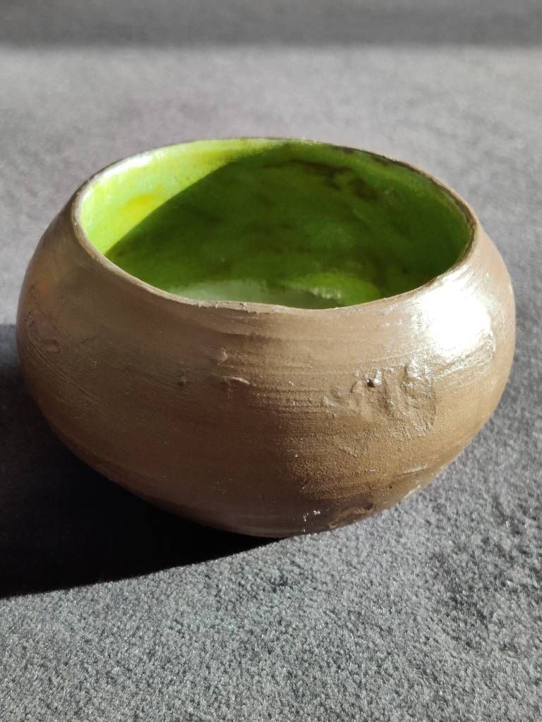 Petit pot en argile dont l'extérieur est laissé brut (argile marron, légèrement brillante car recouverte de cire) et intérieur vert anis.