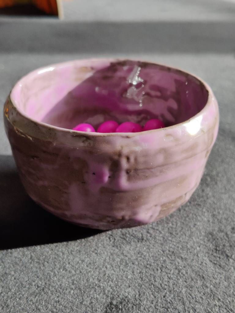 Pot en argile recouvert d'émail mauve posé de façon très irrégulière avec des "pâtés" et des traces quasi transparentes.