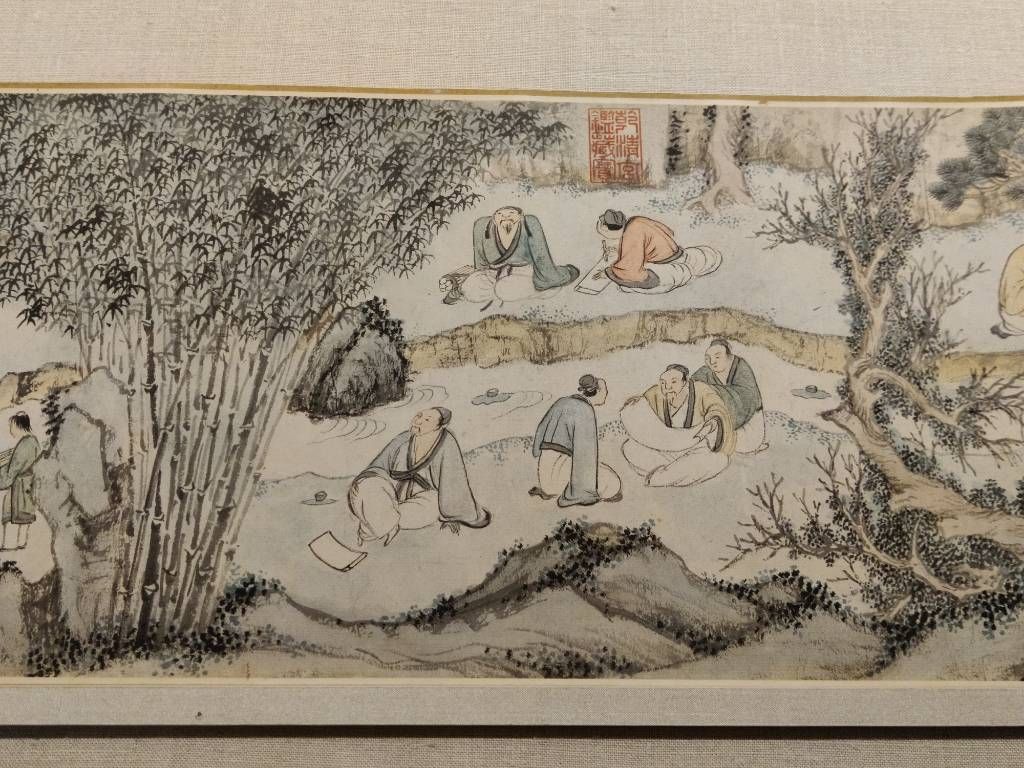 Détail d'un rouleau où l'on voit des hommes assis au bord d'une rivière, certain calligraphiant ou dessinant, d'autres en discussion, un autre en contemplation