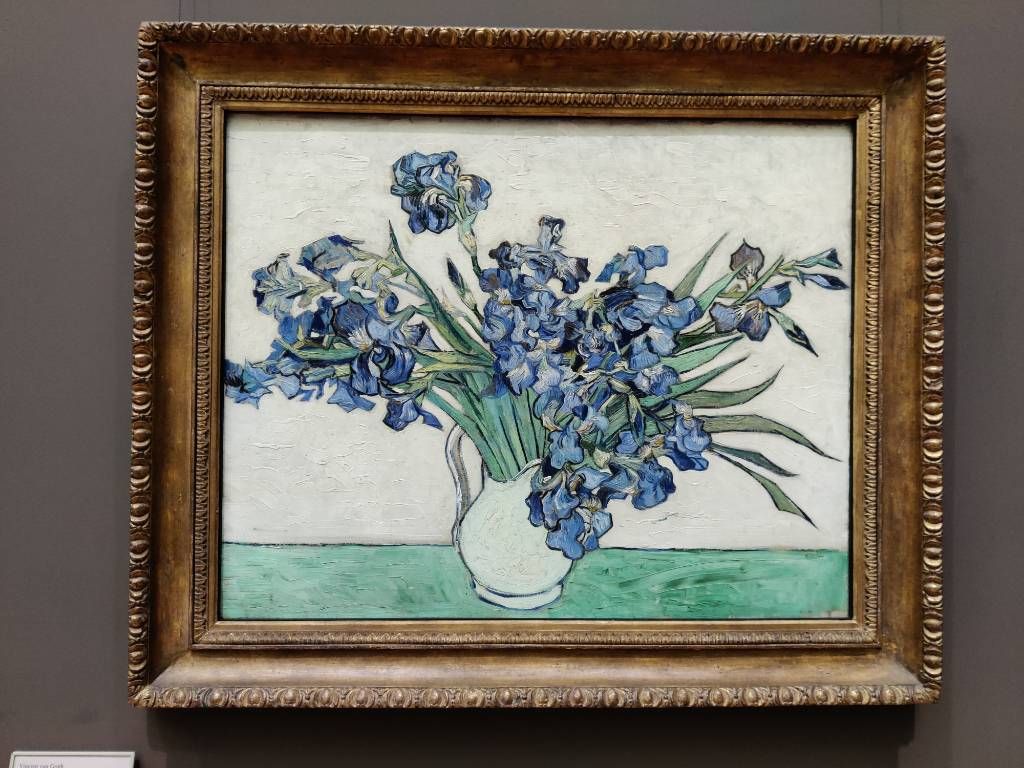 Tableau d'un bouquet d'iris bleus dans un pot à eau blanc