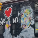 Graffiti s'étalant sur toute la façade d'un bâtiment de deux étages représentant Albert Einstein tirant la langue tagguant "We [cœur] NY²"