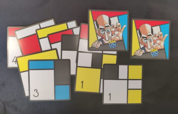 Des cartes carrées recto - des rectangles rouges, noirs, jaunes, blancs - et verso - un homme dégarni se concentrant avant de lancer un dé