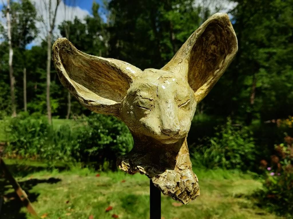 Sculpture d'une tête de chat à grandes oreilles (type chat égyptien. Il fait un peu penser au Chat du rabbin de Joan Sfar)