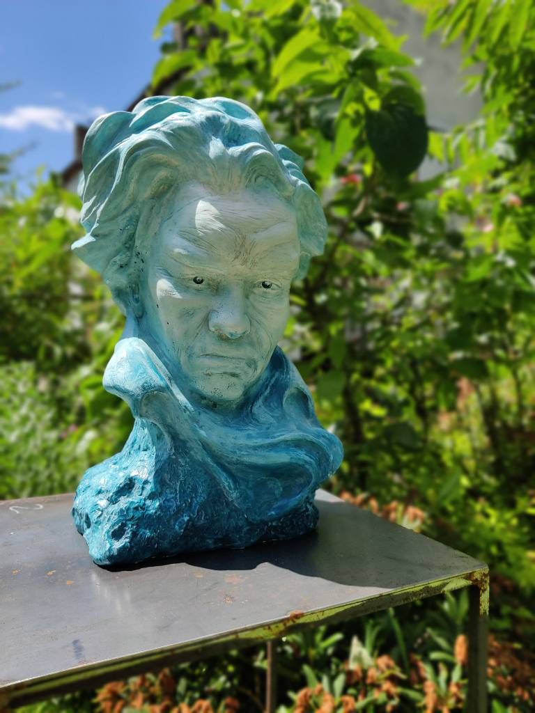 Une sculpture bleue d'un visage ; on devine un portrait de Beethoven