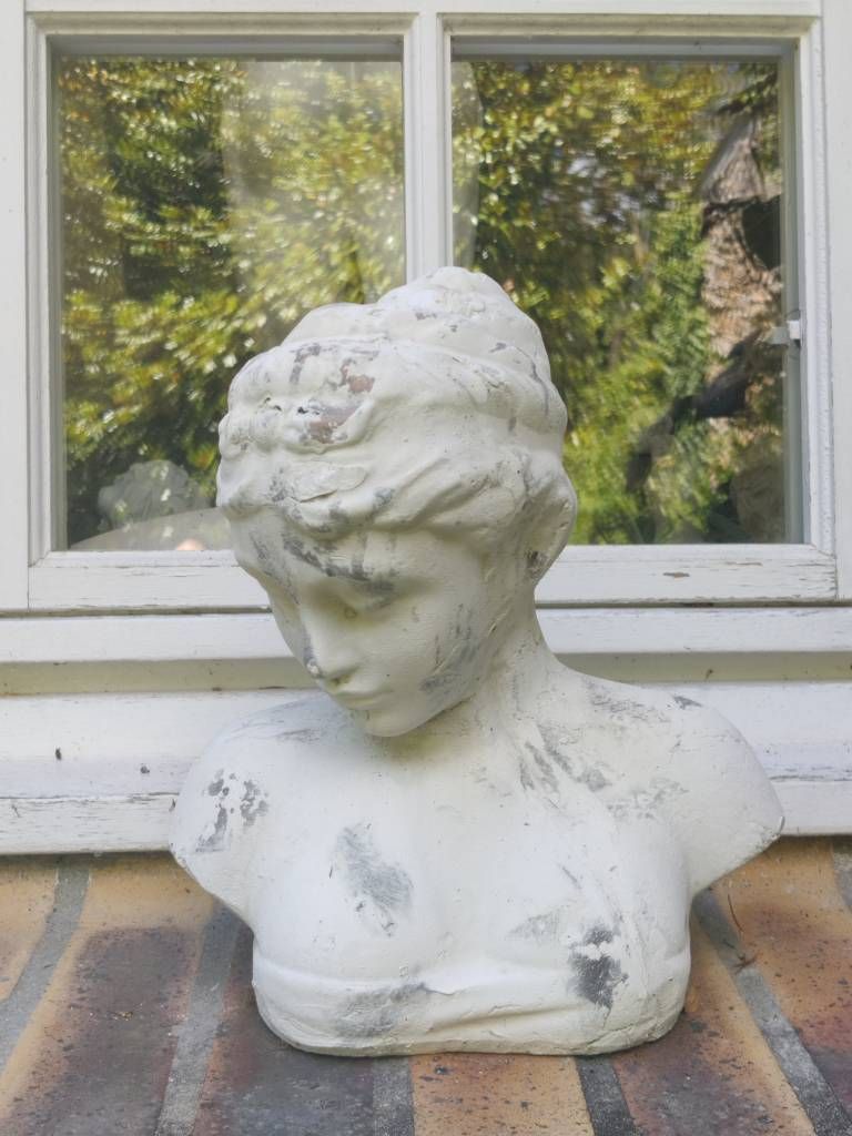 Sculpture d'un buse de jeune fille posé sur un rebord de fenêtre